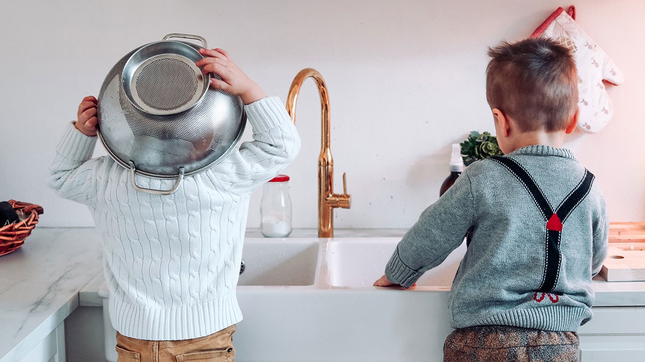 To små barn ved kjøkkenvasken